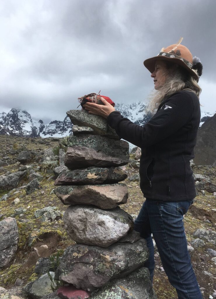 Annette Lachmann legt einen Stein auf eine Apacheta in den Anden