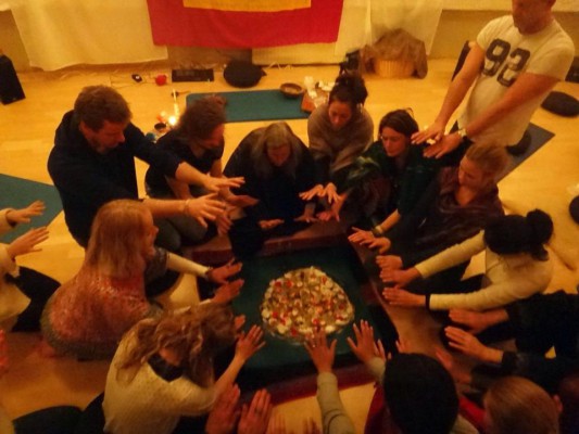 Gruppe sitzt im Kreis um einen Zeremonienaltar